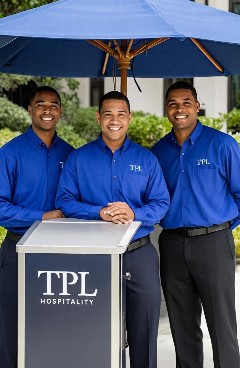 Three TPL valet team members in blue shirts standing together at the company valet stand